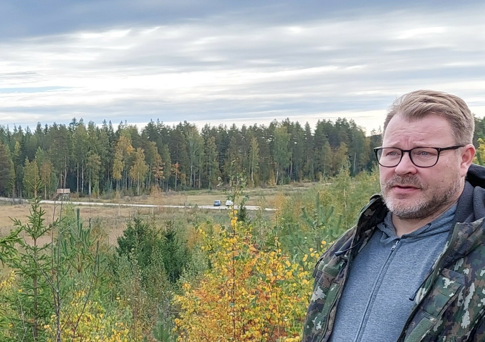 Pekka Hintsanen taustallaan Iitlahden kosteikko ja lintutorni.